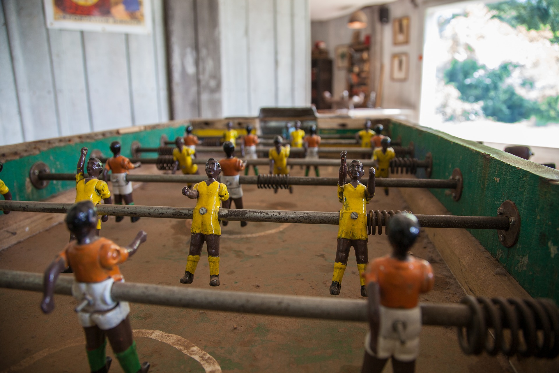 a real life foosball table showing the characters, the field you play on, the rods that players move to interact.